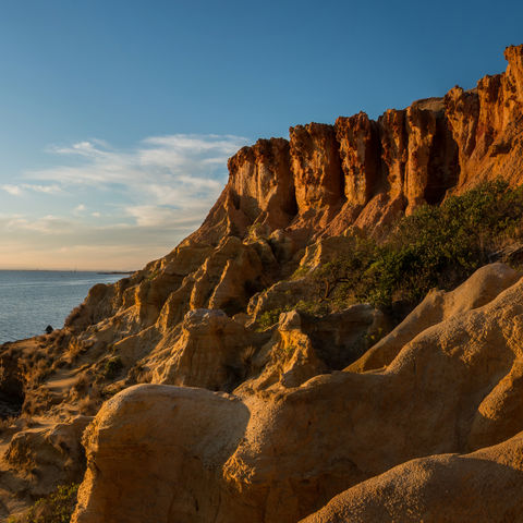 Sonnenuntergang am schwarzen Felsstrand (Black Rock Beach) nahe Melbourne, Australien